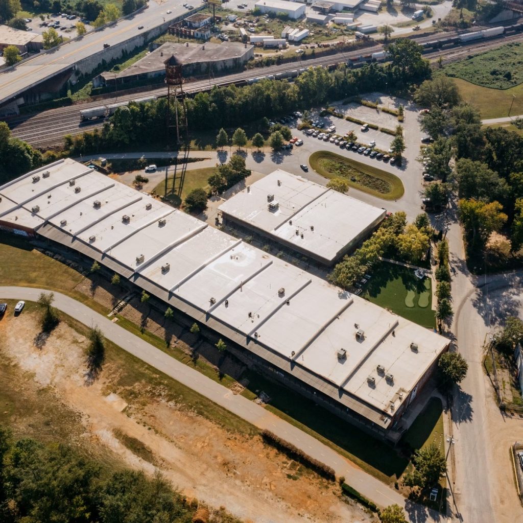 Aerial view of large commercial flat roofing systems for roofing contractor services near me